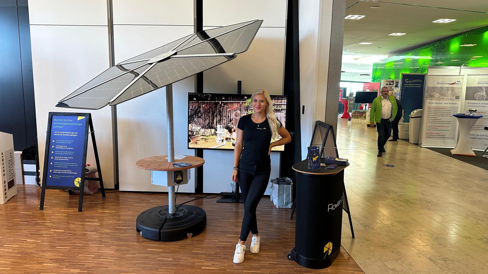 Kleiner FlowerPV Solar-Schirm mit Solardach, Ablage und mobilem Standfuß am Messestand